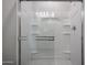 Modern tiled shower with glass door, built in shelving, and neutral color palette at 35315 W La Paz St, Maricopa, AZ 85138