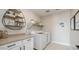 Bright laundry room with white cabinets and shelving at 12712 W Corona Ave, Avondale, AZ 85392