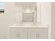 Bathroom showcasing a double sink vanity with mirrors and a clear view of the glass-enclosed shower at 16001 W Cottontail Ln, Surprise, AZ 85387