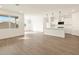 A spacious living room with wood look tile flooring opening to the kitchen and a window at 16001 W Cottontail Ln, Surprise, AZ 85387