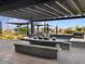 Outdoor kitchen featuring a built-in barbecue, bar seating and dining area under a pergola at 16001 W Cottontail Ln, Surprise, AZ 85387