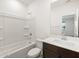 Bathroom with white vanity, dark cabinets, and tub with shower at 16005 W Cottontail Ln, Surprise, AZ 85387