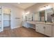 Elegant bathroom with double vanity, granite countertop, and walk-in closet at 18955 W Ocotillo Rd, Waddell, AZ 85355
