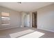 Bright bedroom with carpet flooring, large window, and access to bathroom at 18955 W Ocotillo Rd, Waddell, AZ 85355