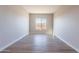 Spacious bedroom with large window, wood-look tile floors, and neutral wall colors at 18955 W Ocotillo Rd, Waddell, AZ 85355