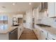 Modern kitchen with white cabinets, granite countertops, and stainless steel appliances at 18955 W Ocotillo Rd, Waddell, AZ 85355