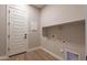 Bright laundry room with upper cabinets and door at 18955 W Ocotillo Rd, Waddell, AZ 85355