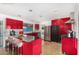 Modern kitchen featuring sleek red cabinetry, stainless steel appliances, and a breakfast bar at 3033 E Sierra St, Phoenix, AZ 85028