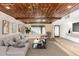Stylish living room featuring wood-paneled ceiling, exposed brick walls, and contemporary furnishings at 3033 E Sierra St, Phoenix, AZ 85028