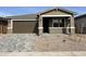 Charming single-story home featuring a low-maintenance desert landscape and a modern gray brick driveway at 40000 W Elm Dr, Maricopa, AZ 85138