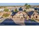 Expansive aerial view of a two-story home with a tile roof, three-car garage, and lush surroundings at 1663 S Boulder St, Gilbert, AZ 85295