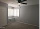 Neutral bedroom with a ceiling fan, plush carpet, a window with shutters, and a built-in window seat at 19537 N 69Th Ave, Glendale, AZ 85308
