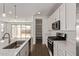 Modern kitchen featuring white cabinets, stainless steel appliances, and a view of the outdoor patio at 40005 W Elm Dr, Maricopa, AZ 85138