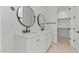 Bright bathroom featuring a dual sink vanity with modern fixtures and round mirrors at 4405 N 203Rd Ave, Buckeye, AZ 85396