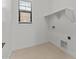 Minimalist laundry room with a window, storage shelf, and tile floors at 4405 N 203Rd Ave, Buckeye, AZ 85396