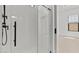 Elegant shower with a glass enclosure, sleek black fixtures, and white subway tile at 4405 N 203Rd Ave, Buckeye, AZ 85396