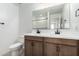 Modern bathroom featuring double vanity, dark wood cabinets, and a large mirror at 11606 W Beck Dr, Youngtown, AZ 85363