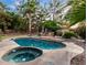 Inviting backyard pool and spa features a stone patio and lush landscaping, perfect for outdoor entertaining at 1201 E Le Marche Ave, Phoenix, AZ 85022