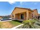 Backyard featuring a pool, covered patio, grass area, and desert landscaping at 18428 W Robin Ln, Surprise, AZ 85387