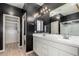 Modern bathroom featuring a dual sink vanity, large mirror, and access to the spacious walk-in closet at 18428 W Robin Ln, Surprise, AZ 85387