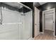 Modern bathroom showcasing a frameless glass shower, white tile, and access to a spacious closet at 18428 W Robin Ln, Surprise, AZ 85387