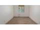 Versatile empty room with wood-look flooring, a window, neutral paint, and baseboards at 18428 W Robin Ln, Surprise, AZ 85387