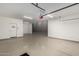Well-lit garage featuring durable flooring, white walls, and a side entry door at 18428 W Robin Ln, Surprise, AZ 85387