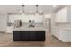 Modern kitchen features an island, stainless steel appliances, white cabinets, and stylish pendant lighting at 18428 W Robin Ln, Surprise, AZ 85387
