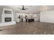 Expansive open-concept living space features fireplace, a modern kitchen, and stylish wood-look flooring at 18428 W Robin Ln, Surprise, AZ 85387