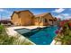 Inviting backyard pool and spa, surrounded by patio, landscaping, and charming architecture at 18428 W Robin Ln, Surprise, AZ 85387