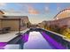 Long shot of a backyard featuring a pool with LED lighting, patio, and desert landscaping at 18428 W Robin Ln, Surprise, AZ 85387