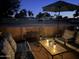 Cozy patio with comfortable seating, a fire pit, and view of the horse property at dusk at 7706 N 173Rd Ave, Waddell, AZ 85355