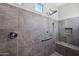 Modern bathroom featuring gray tile walls, walk-in shower, and built-in bench at 27478 W Tonopah Dr, Buckeye, AZ 85396