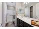 Bathroom featuring dual vanity, large mirror and a shower with glass doors at 27478 W Tonopah Dr, Buckeye, AZ 85396