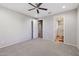 Bedroom with neutral carpet, ceiling fan, and doors to bathroom and closet at 27478 W Tonopah Dr, Buckeye, AZ 85396