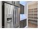 Elegant kitchen featuring stainless steel appliances, dark cabinets and a well-organized pantry at 27478 W Tonopah Dr, Buckeye, AZ 85396