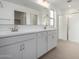 Bright bathroom featuring double sinks, a large mirror, and a glass-enclosed shower at 9042 N 116Th Ln, Youngtown, AZ 85363
