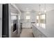 Kitchen with stainless steel appliances, white cabinets, island, and patio access at 9042 N 116Th Ln, Youngtown, AZ 85363