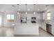 Bright kitchen with stainless steel appliances, white cabinets, a large island, and tile floors at 9042 N 116Th Ln, Youngtown, AZ 85363