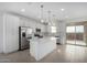 Bright kitchen with stainless steel appliances, white cabinets, large island and patio access at 9042 N 116Th Ln, Youngtown, AZ 85363