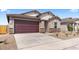 Well-maintained single-story home featuring a spacious driveway and appealing desert-style landscaping at 16620 N Dante Way, Maricopa, AZ 85138