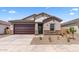 Attractive single-story home showcasing a two-car garage and low-maintenance desert landscaping at 16620 N Dante Way, Maricopa, AZ 85138