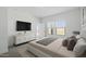 This staged bedroom features a modern dresser, a tv, and natural light at 16610 N Dante Way, Maricopa, AZ 85138