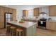 Charming kitchen with light wood cabinets, stainless steel appliances, and a center island with seating at 249 N 89Th St, Mesa, AZ 85207