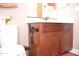 Bathroom featuring wooden vanity, white sink, bidet sprayer, and neutral-colored wall with towel at 10539 E Corbin Ave, Mesa, AZ 85212