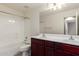 Bathroom with a double sink vanity with dark wood cabinets and shower/tub combo at 4102 S 186Th Ave, Goodyear, AZ 85338