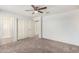 Neutral bedroom with plush carpet, ceiling fan, closets, and multiple entryways at 4102 S 186Th Ave, Goodyear, AZ 85338