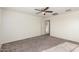 Bright bedroom with ceiling fan, carpet, and a doorway to a walk-in closet at 4102 S 186Th Ave, Goodyear, AZ 85338