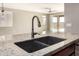 Close-up of a kitchen sink, with granite countertops and view to the living room and backyard at 4102 S 186Th Ave, Goodyear, AZ 85338