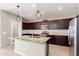 Modern kitchen with granite countertops, stainless steel appliances, and stylish pendant lighting at 4102 S 186Th Ave, Goodyear, AZ 85338